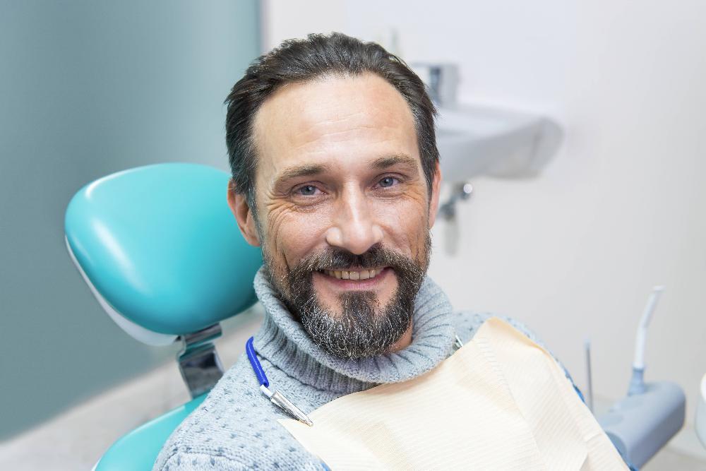 man sitting in dental exam chair | dentist wilmington de